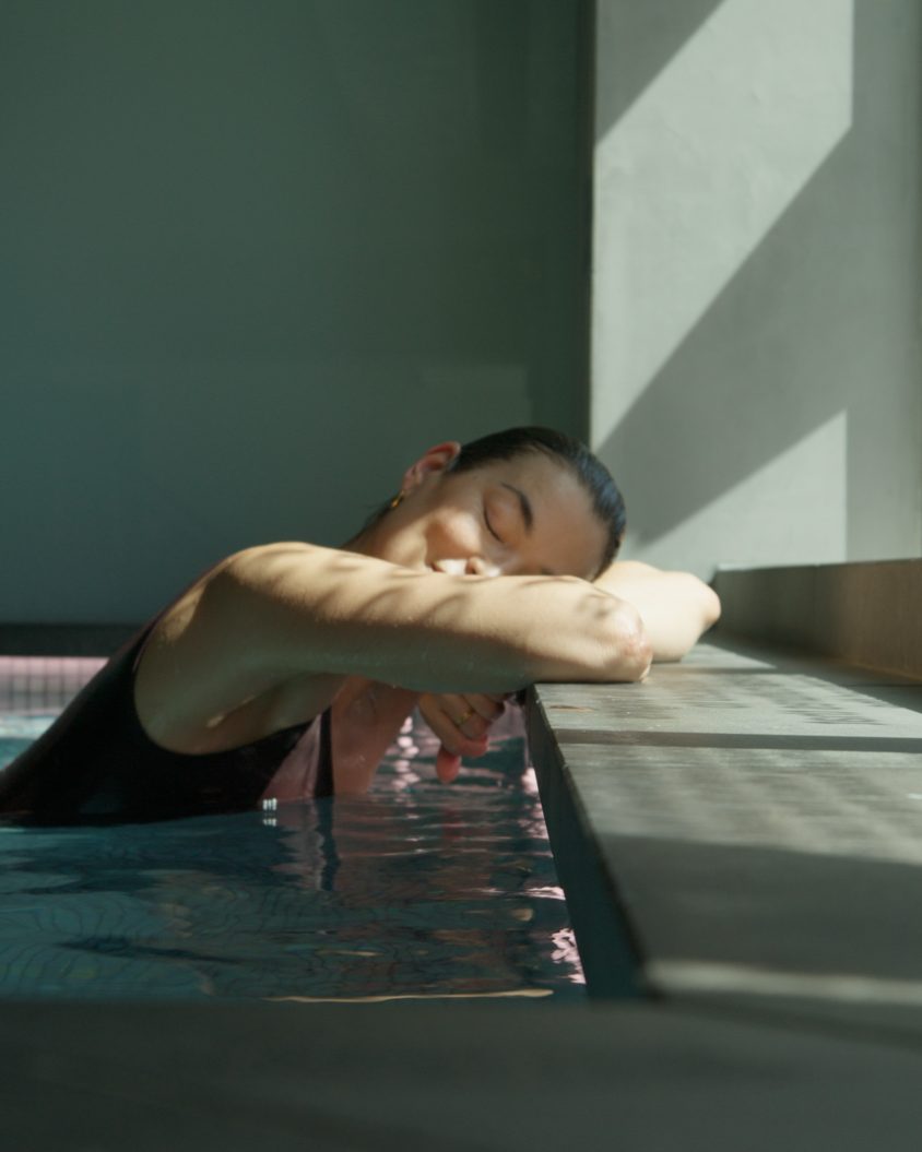 A guest resting at the edge of the mineral pool at the EQ Bathhouse