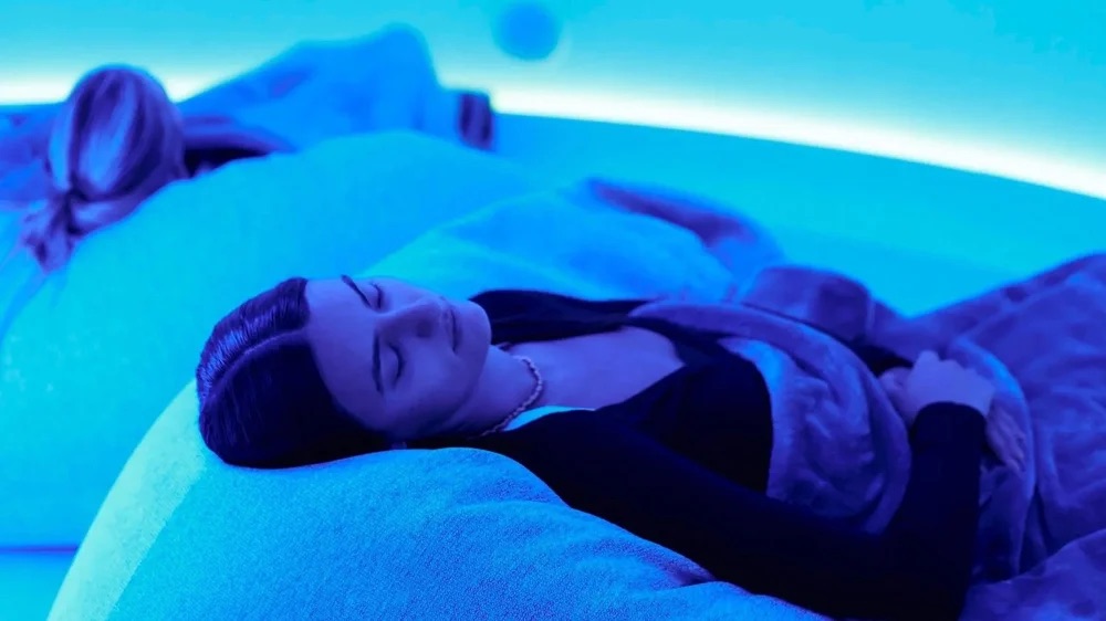 A guest reclined under coloured light in the EQ dome